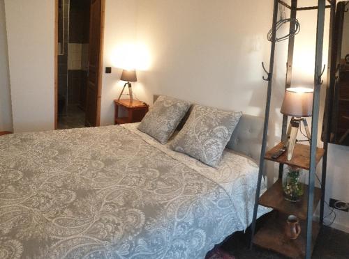a bedroom with a bed and two pillows on it at Chambre à la campagne in Mézières-sur-Couesnon