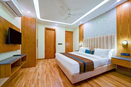 a hotel room with a bed and a television at FabHotel Soft Petals in Gurgaon