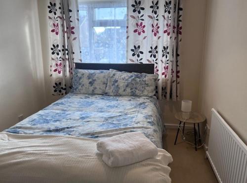 a bedroom with a bed and a window with curtains at Newport Pagnell Guest House in Buckinghamshire