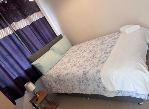 a bedroom with a bed with a purple curtain at Newport Pagnell Guest House in Buckinghamshire