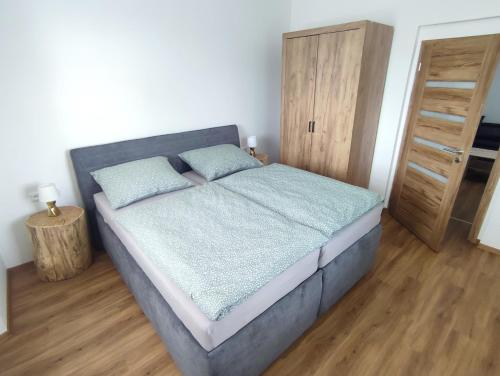 a bedroom with a bed and a wooden floor at Zámeček Čeřov in Jičín
