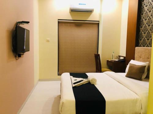 a hotel room with a bed and a television at 7even Hills- International Airport By Glitz Hotels in Mumbai