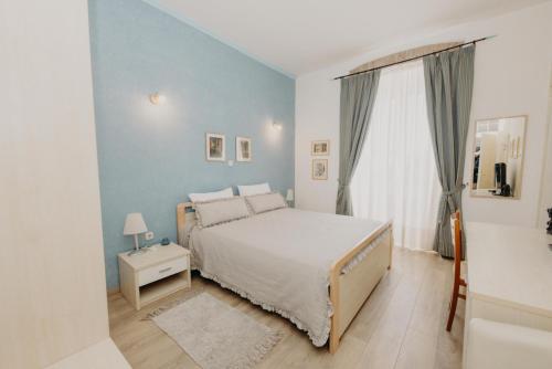 Dormitorio azul con cama y ventana en Rooms and Studios Villa Rossella 2, en Rovinj