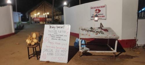 a stand with a table and a sign in a room at Swiss kiss beach resort in Uppuveli