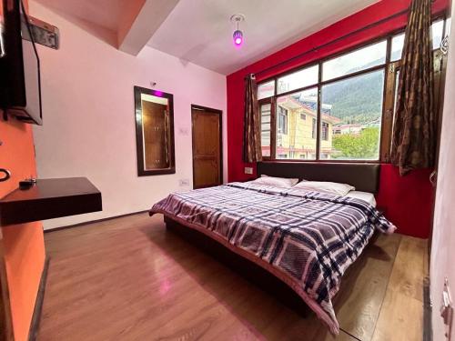 a bedroom with a bed and a large window at Manali Villa in Manāli