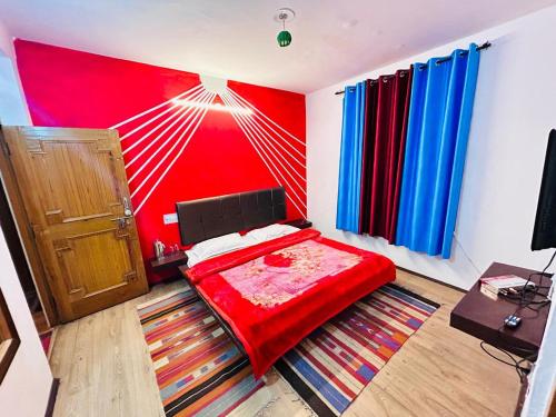 a bedroom with a red wall and a red bed at Manali Villa in Manāli