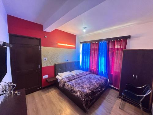 a bedroom with a bed and red and blue walls at Manali Villa in Manāli
