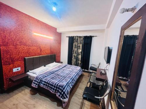 a bedroom with a bed with a red wall at Manali Villa in Manāli