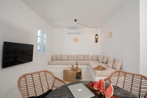 a living room with a couch and a table with a laptop at Soley Naxos in Naxos Chora