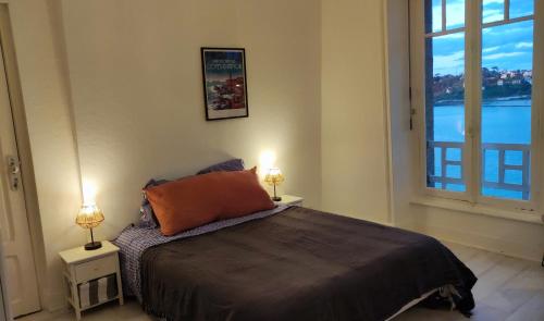 - une chambre avec un lit et deux lampes sur les tables dans l'établissement Splendide vue mer studio, à Perros-Guirec