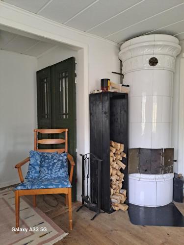 LinnerydにあるBastanäs Rosenbergの椅子と薪ストーブ付きの部屋