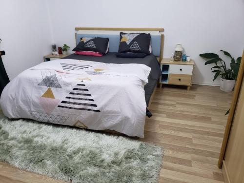 a bedroom with a bed with a comforter and a rug at 2 bedroom duplex Durrës in Durrës
