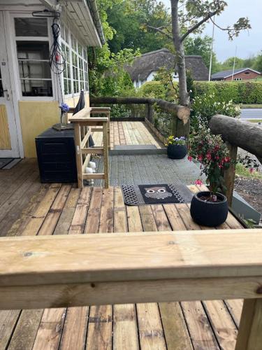 a wooden deck with a bench on a house at Overnatning Filskov in Grindsted