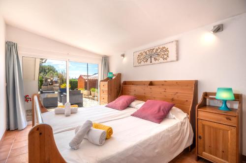 a bedroom with a large white bed with pink pillows at Finca JESUS Pollensa in Port de Pollensa