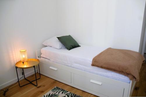 - une petite chambre avec un lit blanc et une lampe dans l'établissement Flik-en-flac - Appartement à 20m de la plage, à Roscoff