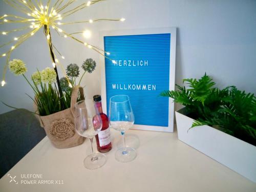 uma mesa com dois copos de vinho e uma foto em Gemütliche 1 Zimmer Ferienwohnung em Ludwigsburg