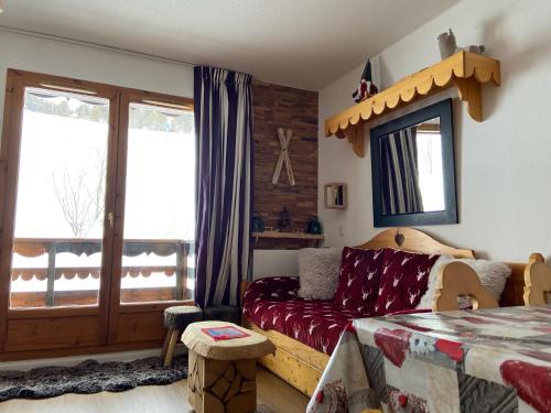 een woonkamer met een bank en een raam bij Pied des Pistes, 2 pièces, 6pers, Piscine et Sauna in Risoul