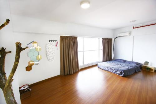 um quarto com uma cama e piso em madeira em Private Beanie (Private Cinema, Swing & more) at CEO Penang em Bayan Lepas
