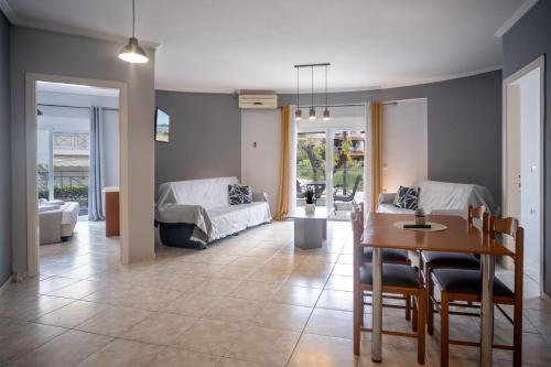a living room with a dining table and a couch at DOMES APARTMENTS in Kallithea Halkidikis