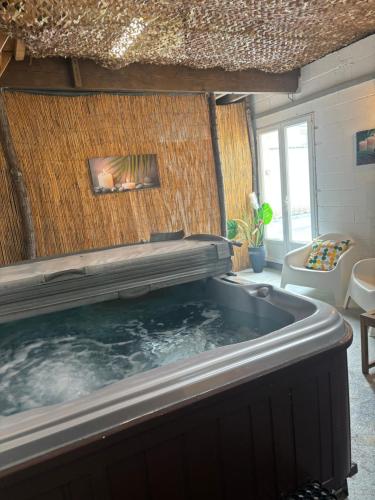 bañera de hidromasaje grande en una habitación con chimenea en gîte coeur de champagne en Romery