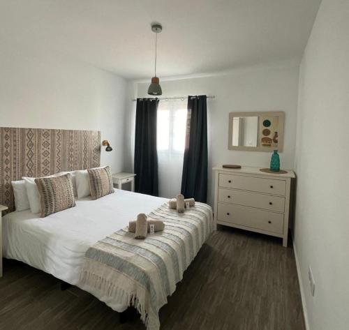 un dormitorio con una cama con dos animales de peluche en Elcano by Best Holidays Fuerteventura en Corralejo