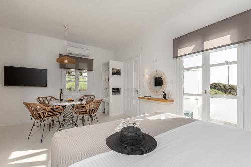 a bedroom with a bed and a table with chairs at Soley Naxos in Naxos Chora