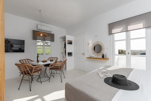 a white room with a table and chairs and a bed at Soley Naxos in Naxos Chora