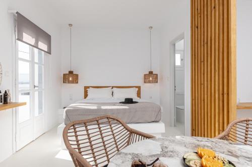 a bedroom with a bed and two chairs and a table at Soley Naxos in Naxos Chora