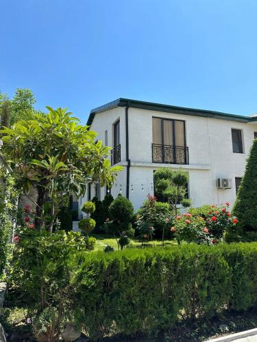 a white house with a garden in front of it at LARDA TBILISI in Tbilisi City