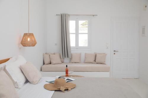 a white living room with a couch and a hat on a bed at Soley Naxos in Naxos Chora
