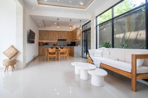 a living room with a white couch and a kitchen at Sundaze 2 - Canggu Paradise with Pool and Kitchen Brand NEW in Kerobokan