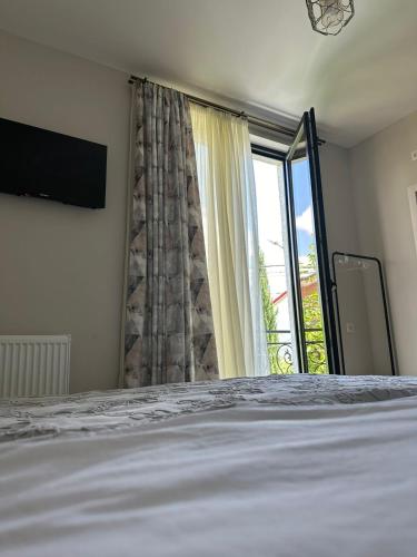 a bedroom with a bed and a large window at LARDA TBILISI in Tbilisi City