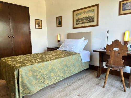 a bedroom with a bed and a desk with a chair at Grand Hotel SIVA - Adults Only in Santo Stefano dʼAveto