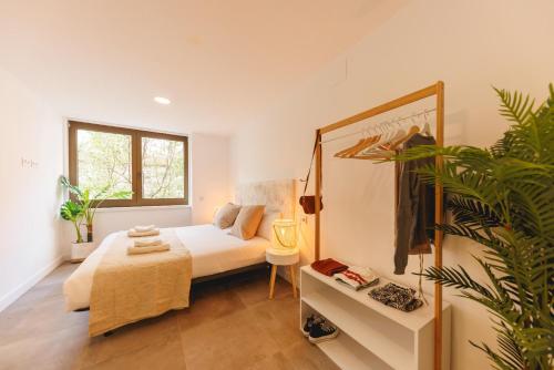 a bedroom with a bed and a potted plant at Bravissimo Turbau Entresol A, with 3 bedrooms in Girona