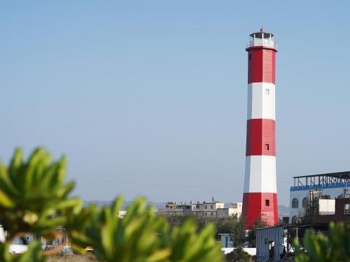 a red and white lighthouse in a city at Gaomei Lighthouse in Taichung