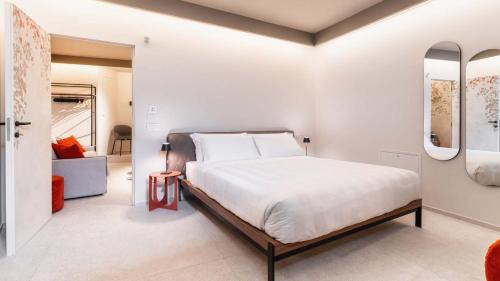 a bedroom with a large bed and two mirrors at Amatera Luxury Apartments in Matera
