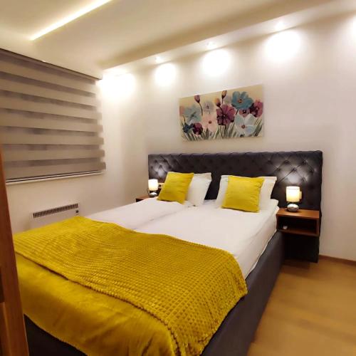 a bedroom with a large bed with yellow pillows at BalkanHill2 S37 Pekovic green in Zlatibor