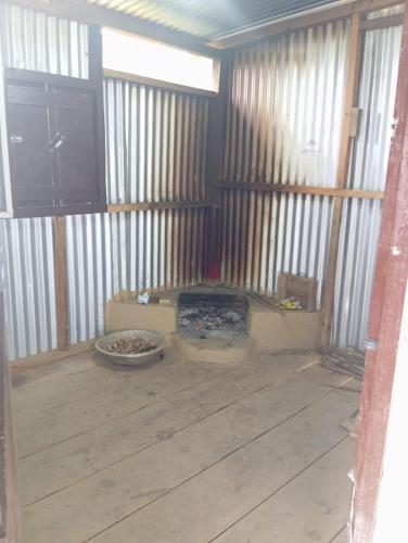ein leeres Zimmer mit Kamin in einer Scheune in der Unterkunft Vilho Homestay 