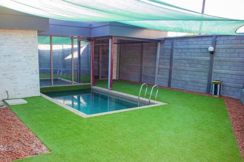 una casa con piscina y césped verde en Uh Ti en Salor