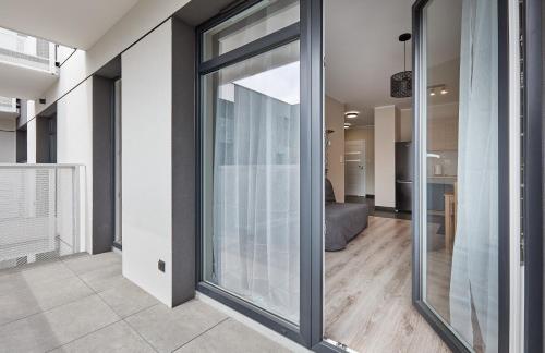 - une porte coulissante en verre dans une pièce avec un salon dans l'établissement Poznań Airport Homely Apartment, à Poznań