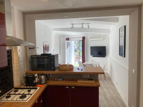 a kitchen with a counter and a stove top oven at LE PETIT HERMITAGE in Apt