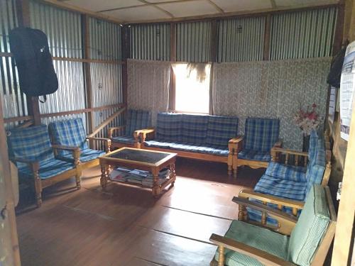 ein Wohnzimmer mit blauen Stühlen und einem Tisch in der Unterkunft Vilho Homestay 