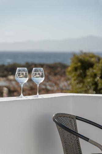 two wine glasses sitting on top of a ledge at Soley Naxos in Naxos Chora