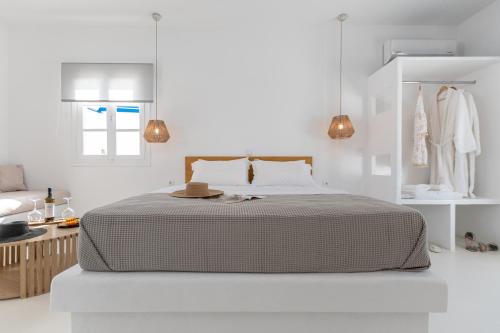a white bedroom with a bed and a window at Soley Naxos in Naxos Chora