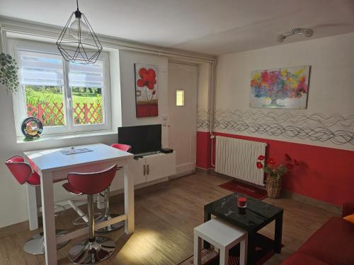 - un salon avec une table blanche et un mur rouge dans l'établissement Appart à la campagne, à Perpezac-le-Noir