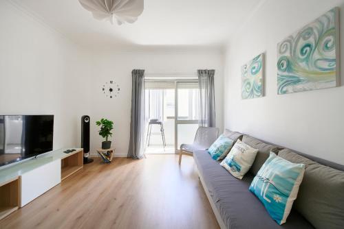 a living room with a couch and a tv at Casandrade 148 - Lisbon South Bay in Cabeço de Alhos Vedros