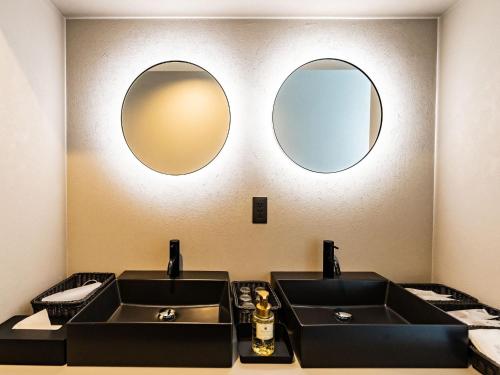 due lavandini in un bagno con due specchi di Izumo Biyori Horikawa Villa - Vacation STAY 28459v a Izumo