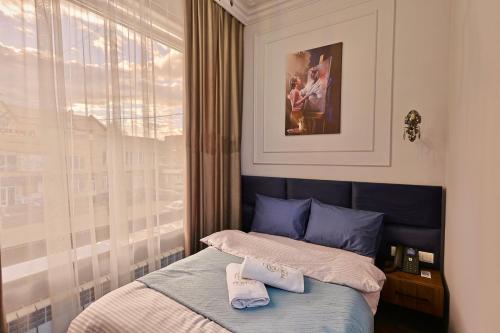 a bedroom with a bed with two towels on it at Fiorella Gyumri in Gyumri