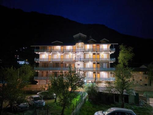 a building at night with cars parked in front of it at Hotel Old Manali - The Best Riverside Boutique Stay with Balcony and Mountain Views in Manāli