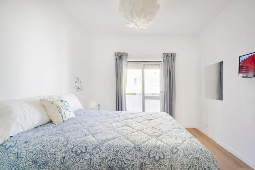 ein weißes Schlafzimmer mit einem Bett und einem Fenster in der Unterkunft Casandrade 148 - Lisbon South Bay in Cabeço de Alhos Vedros